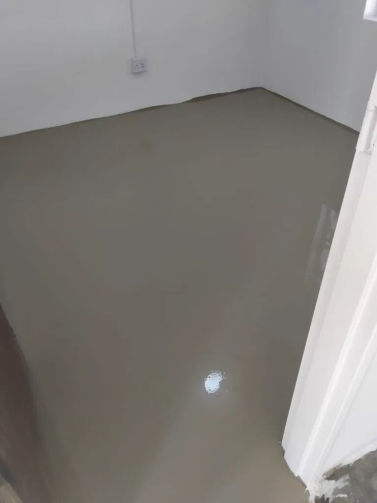 Cured seamless beige epoxy floor with a smooth gloss surface running wall to wall in an empty room