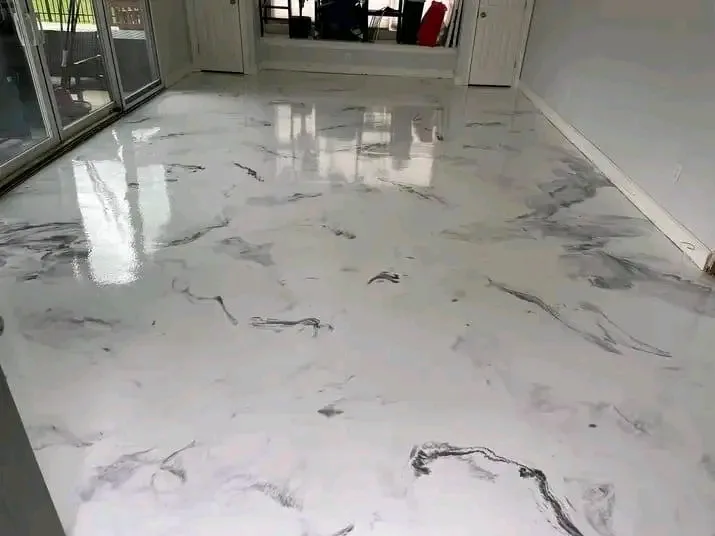 White marble-effect metallic epoxy floor with grey veining in a living room with sliding doors