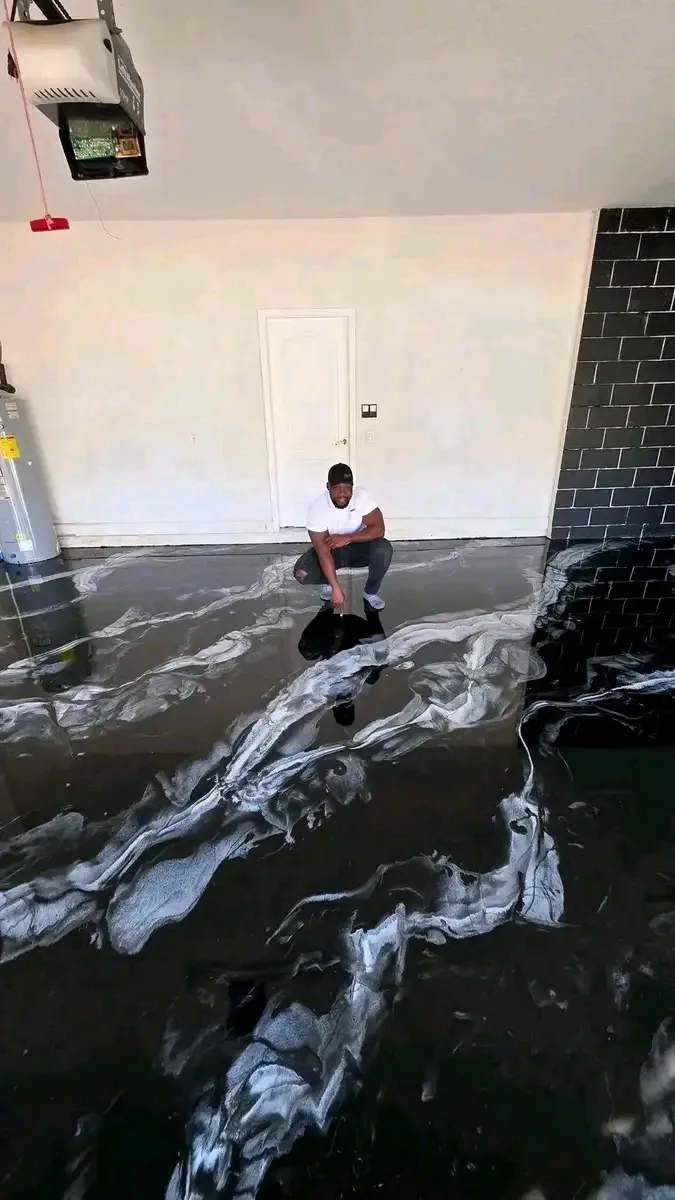 Glossy black and silver metallic epoxy garage floor with a mirror-like reflective finish